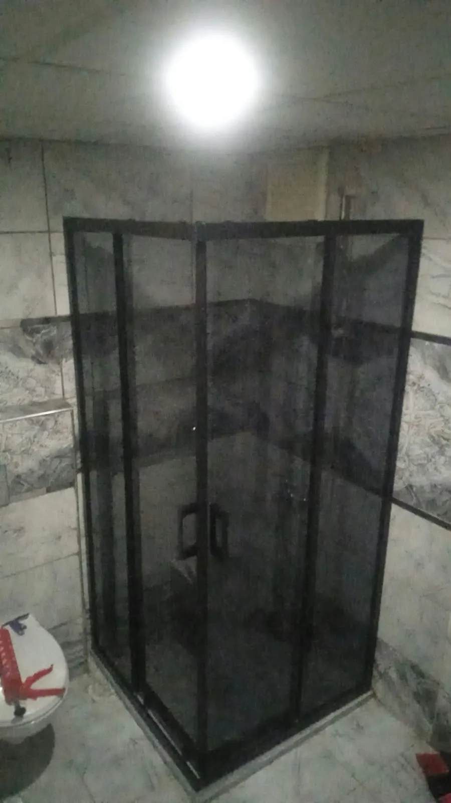 Banyoda monte edilmiş siyah çerçeveli cam duşakabin